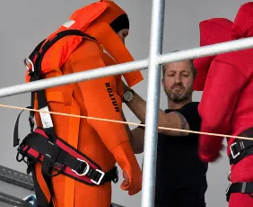 Поставяне на сбруя върху защитен костюм